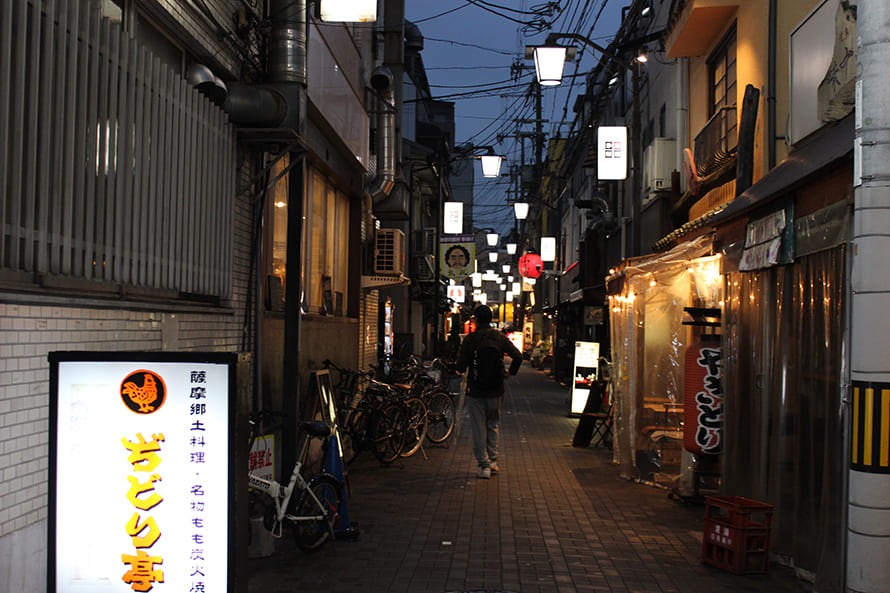 Illuminated restaurant signs in a narrow Fukushima dining lane at night