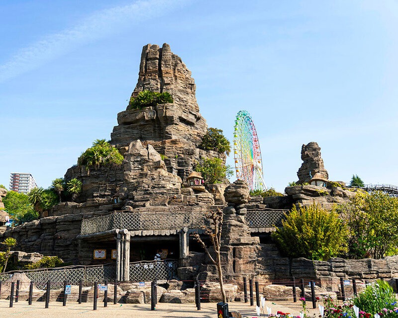 Rock formations and attractions beneath a blue sky at Hirakata Park
