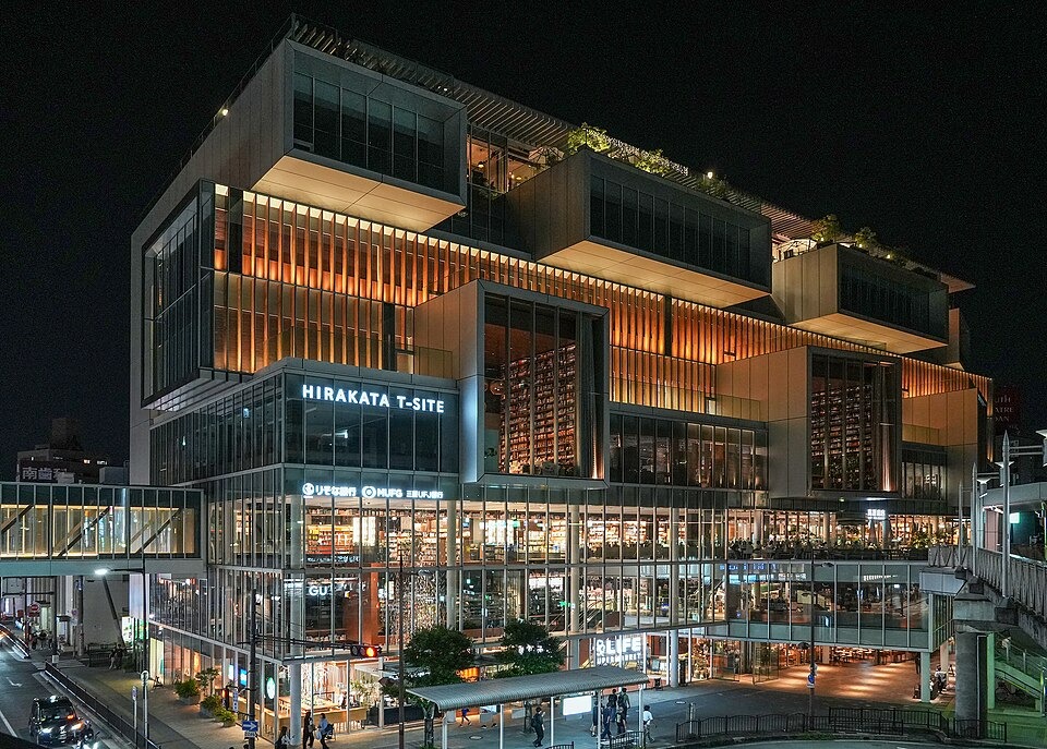 Hirakata T-SITE glowing at night beside Hirakatashi Station