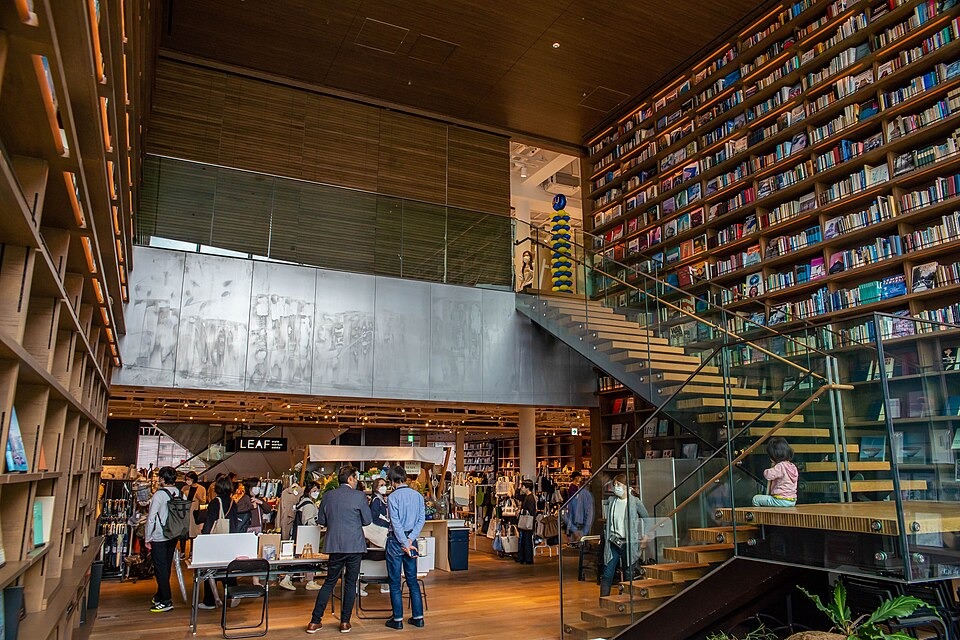 Visitors browsing beneath towering bookshelves at Hirakata Tsutaya Books