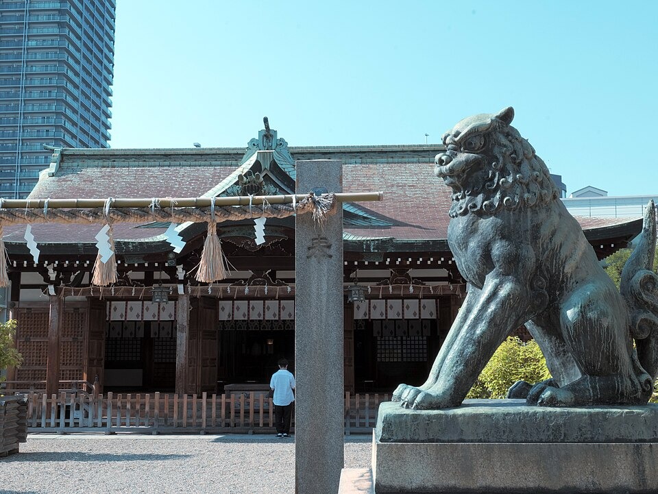 A guardian lion statue beside the shrine hall at Imamiya Ebisu Shrine