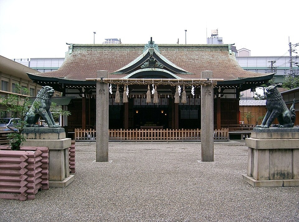The front of Imamiya Ebisu Shrine with a torii and guardian statues