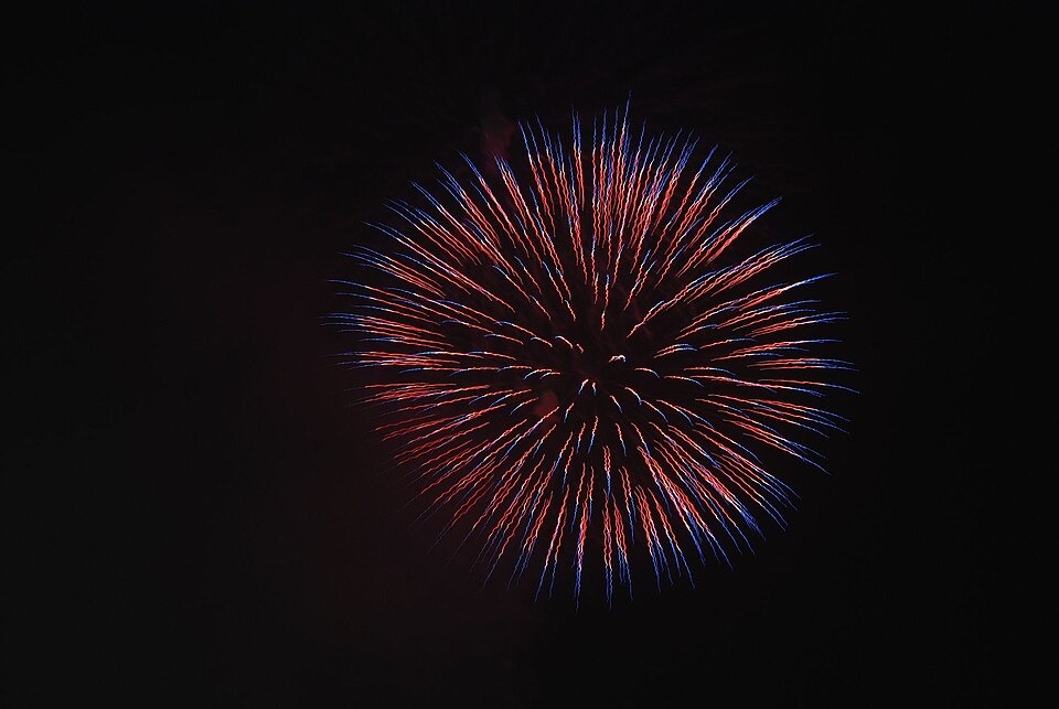 A colorful round firework against the night sky at the Yodogawa fireworks event