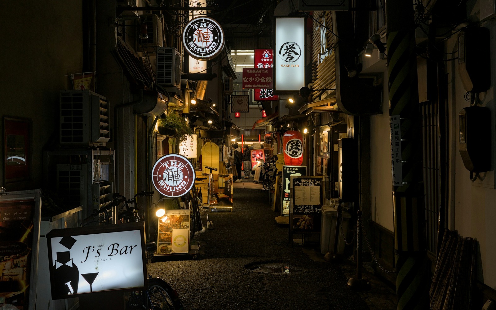 Illuminated bar and restaurant signs in a narrow Umeda alley at night