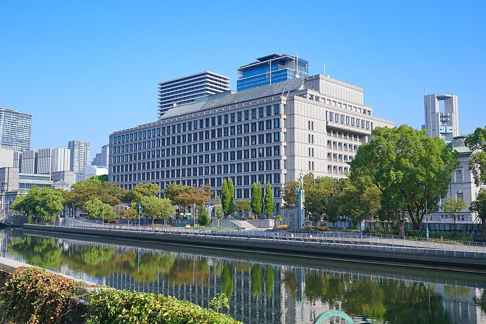 Osaka City Hall beside the river under a clear blue sky