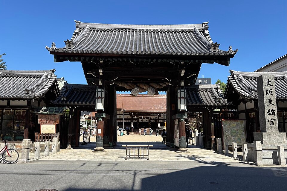 The main gate of Osaka Tenmangu under a clear blue daytime sky