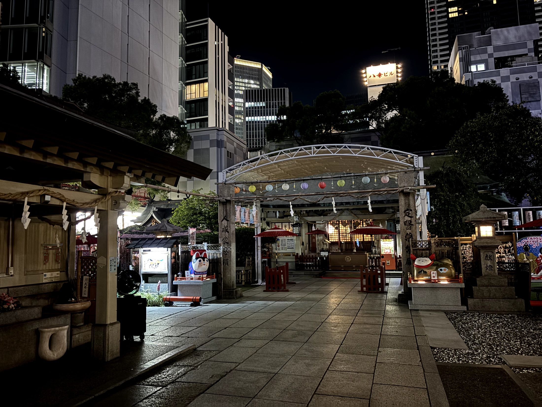 The courtyard of Ohatsu Tenjin Shrine lit up against the surrounding city at night