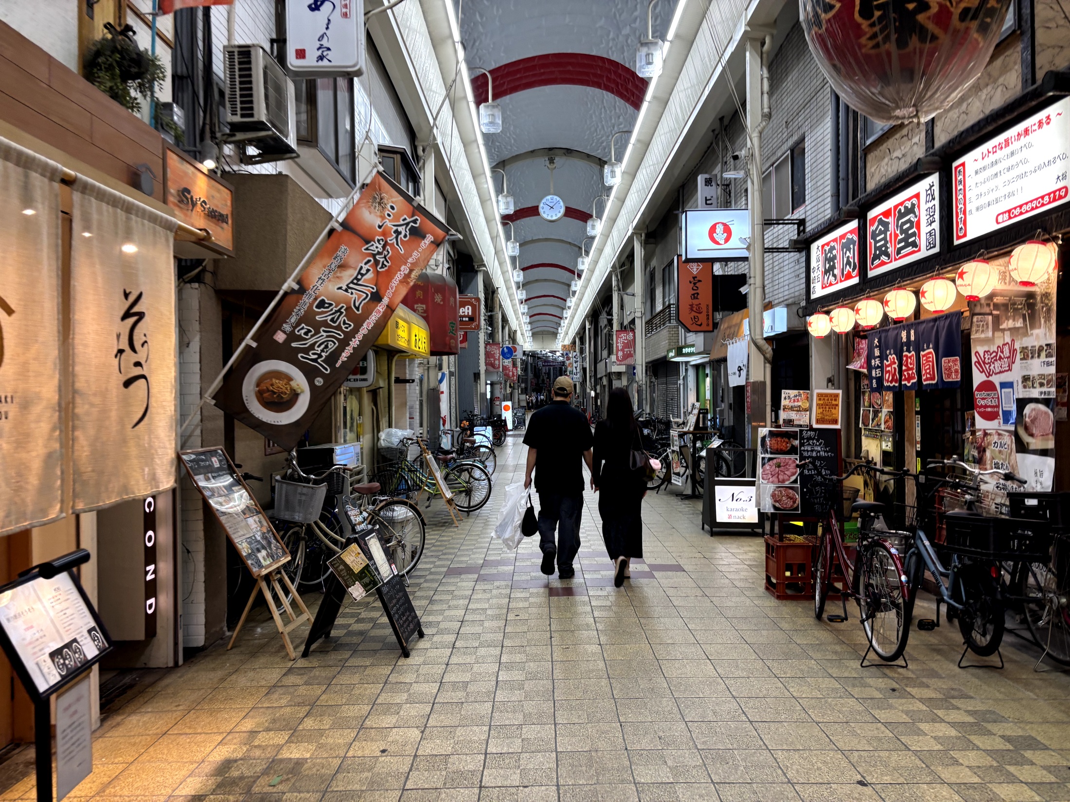 Small restaurants and shop signs under a covered arcade near Nakazakicho
