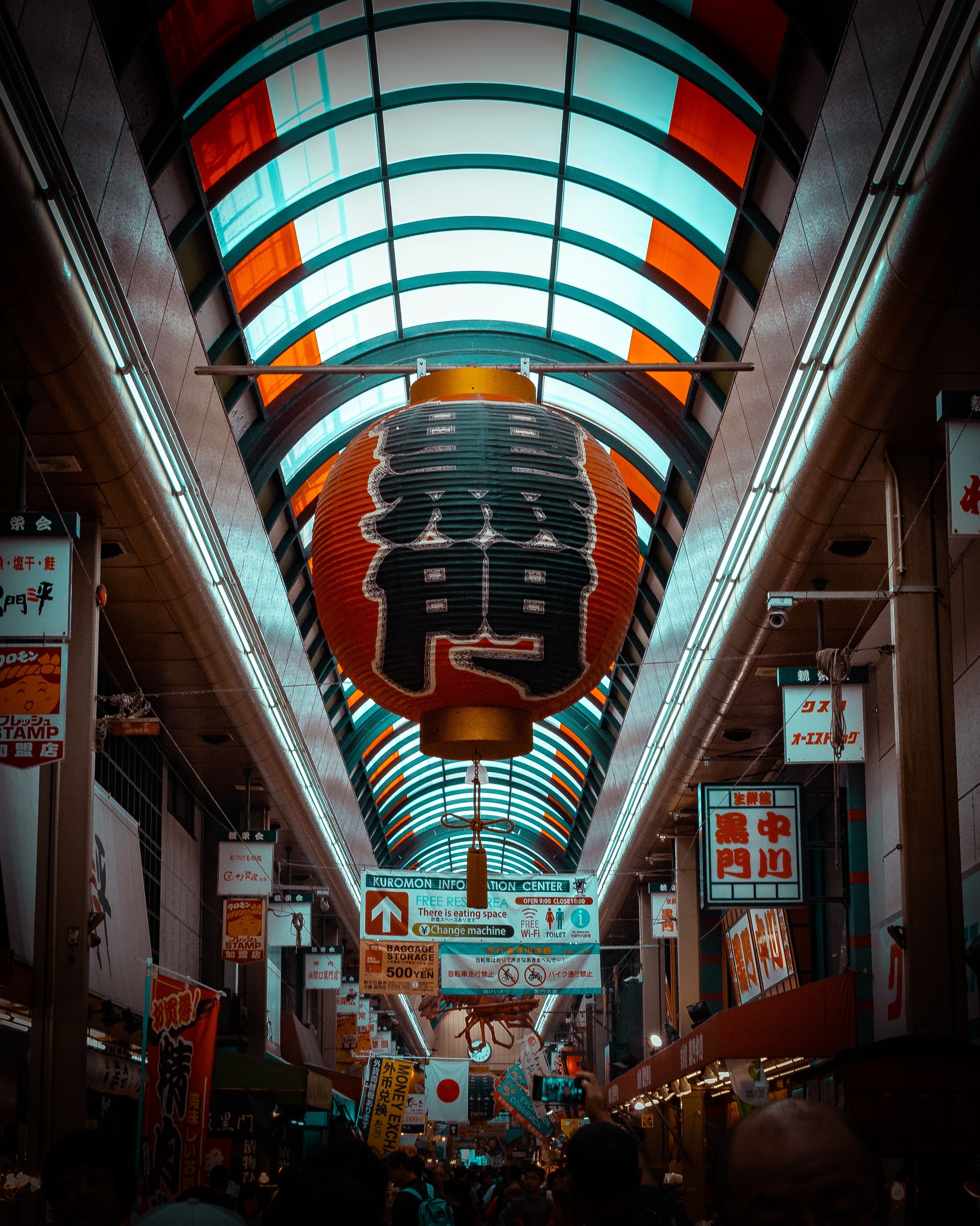 A large Kuromon lantern above shoppers in the covered market