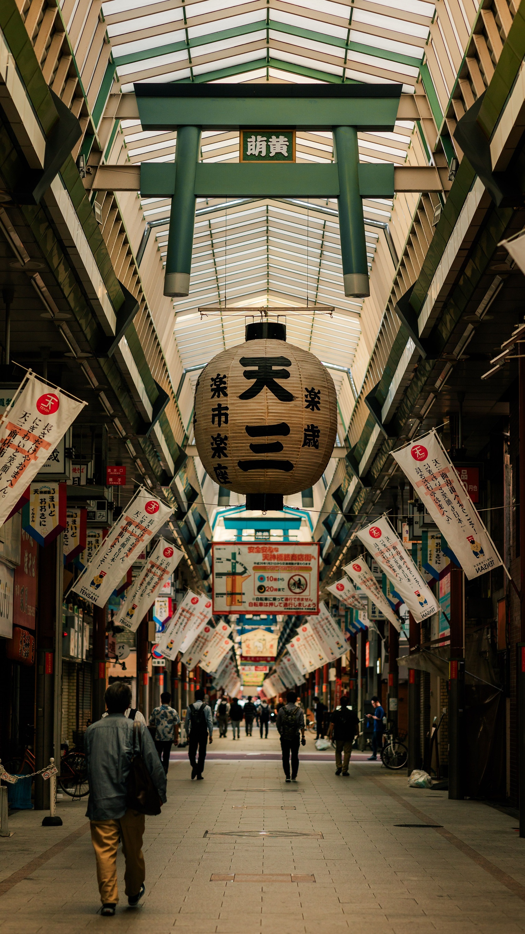 Shoppers walking beneath the Ten-san lantern in Tenjinbashisuji Shopping Street