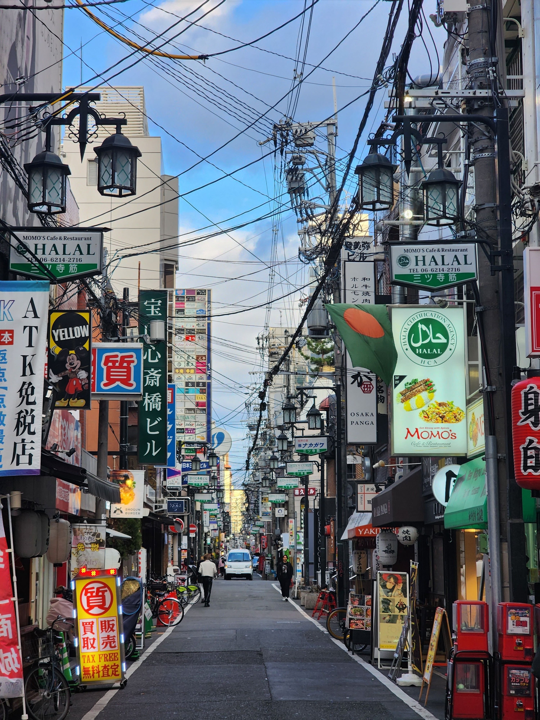 Small restaurants and colorful signs lining a street in the Shinsaibashi area