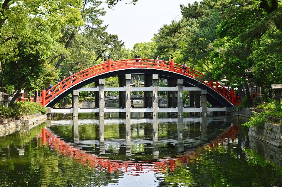 The red Sorihashi bridge and green trees at Sumiyoshi Taisha