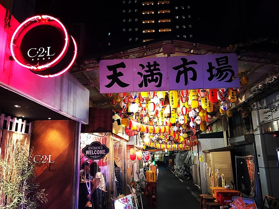 Colorful lanterns and restaurant signs at the Tenma Market entrance after dark